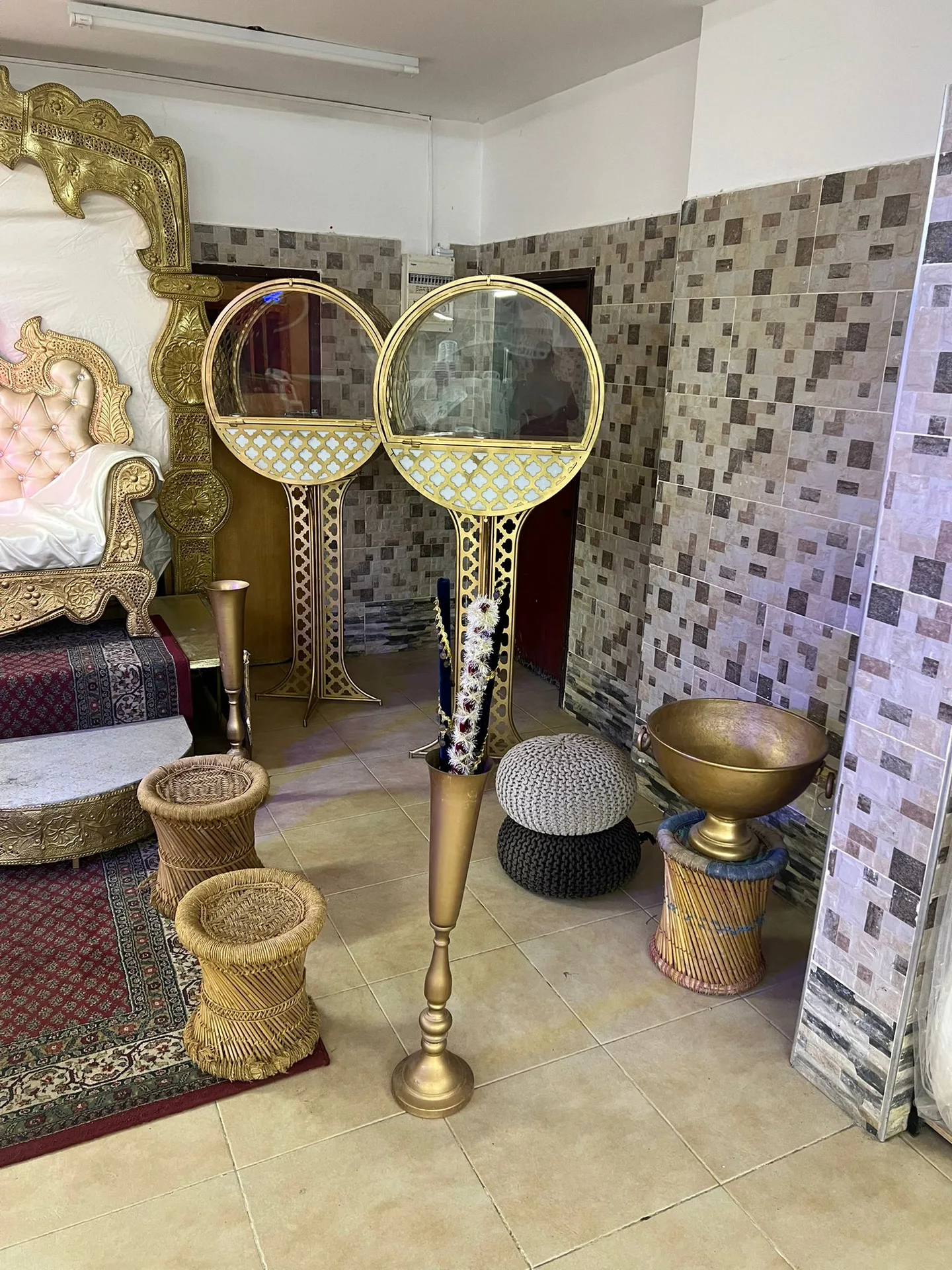 זוג ויטרינות עגולות בגווני זהב לצד אביזרי עיצוב נוספים