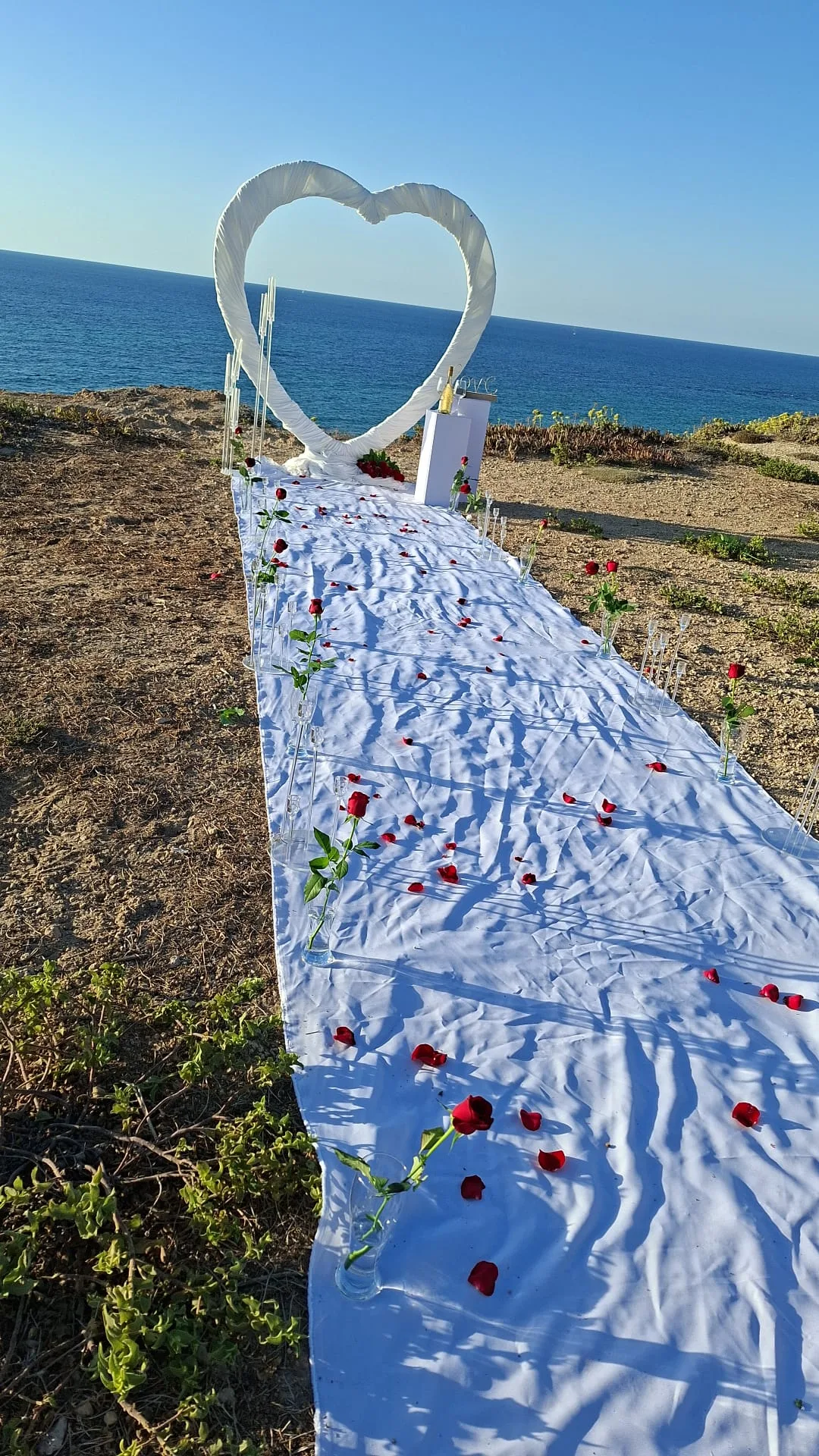 תפאורת לב לבן להצעת נישואין עם שביל מעוטר מול הים