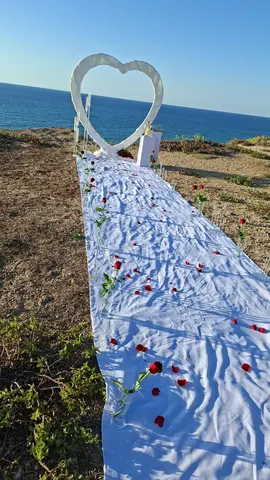 תפאורת לב לבן להצעת נישואין עם שביל מעוטר מול הים